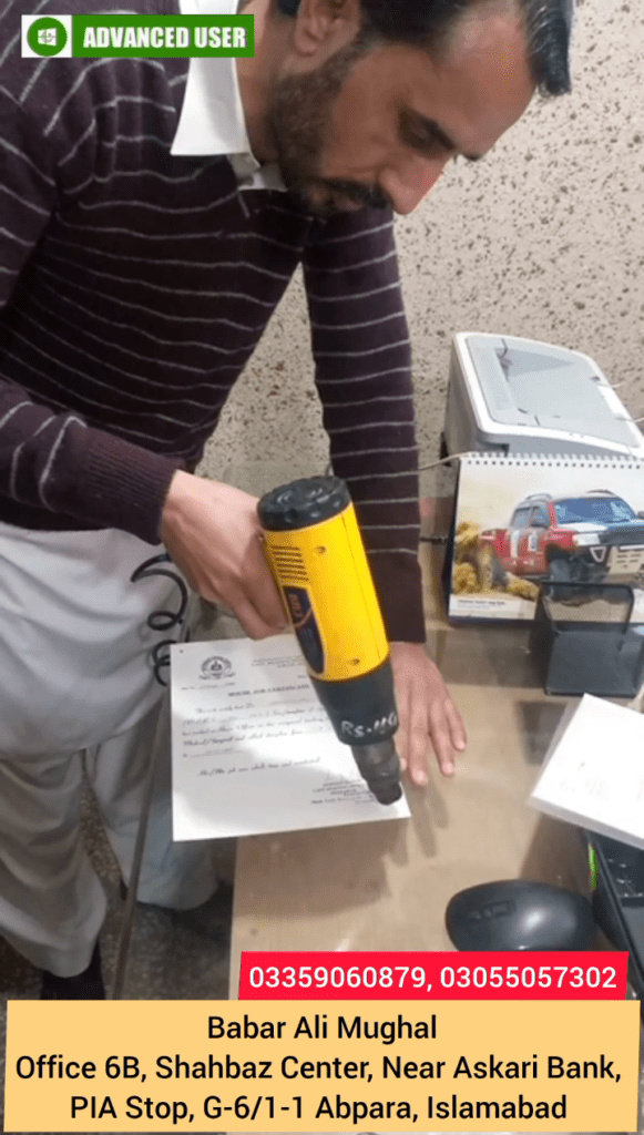 Babar Ali Mughal removing plastic coating from document using a heat gun
